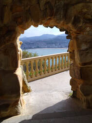 A view of the seafront at San Sebastian through a stone archway