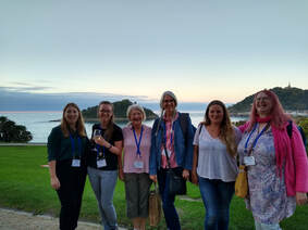 A group of editors standing in front of a view out to sea