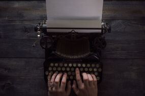 Image showing hands resting on the keyboard of an old manual typewriter